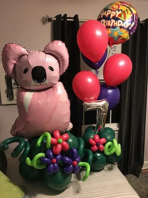 Pink koala balloon sculpture with birthday balloons