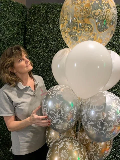 Patty with a gold and white helium bouquet